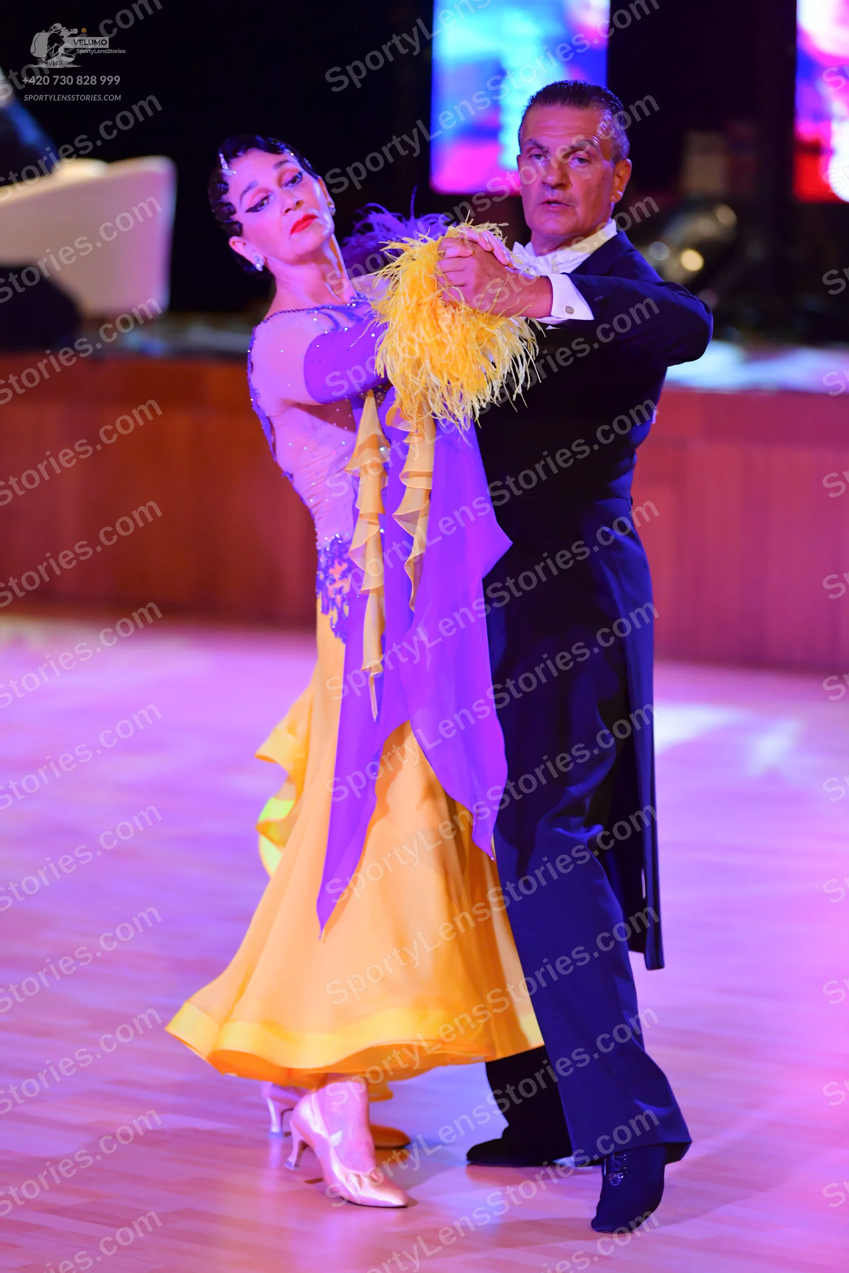 Dancesport competitor: Female dancer: light purple/lavender bodice with a flowing yellow/gold skirt and