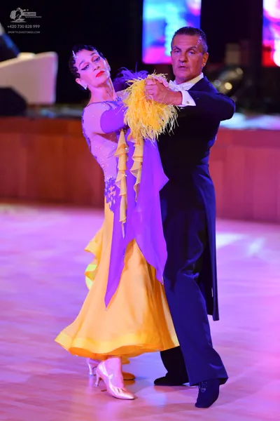 Dancesport competitor: Female dancer: light purple/lavender bodice with a flowing yellow/gold skirt and