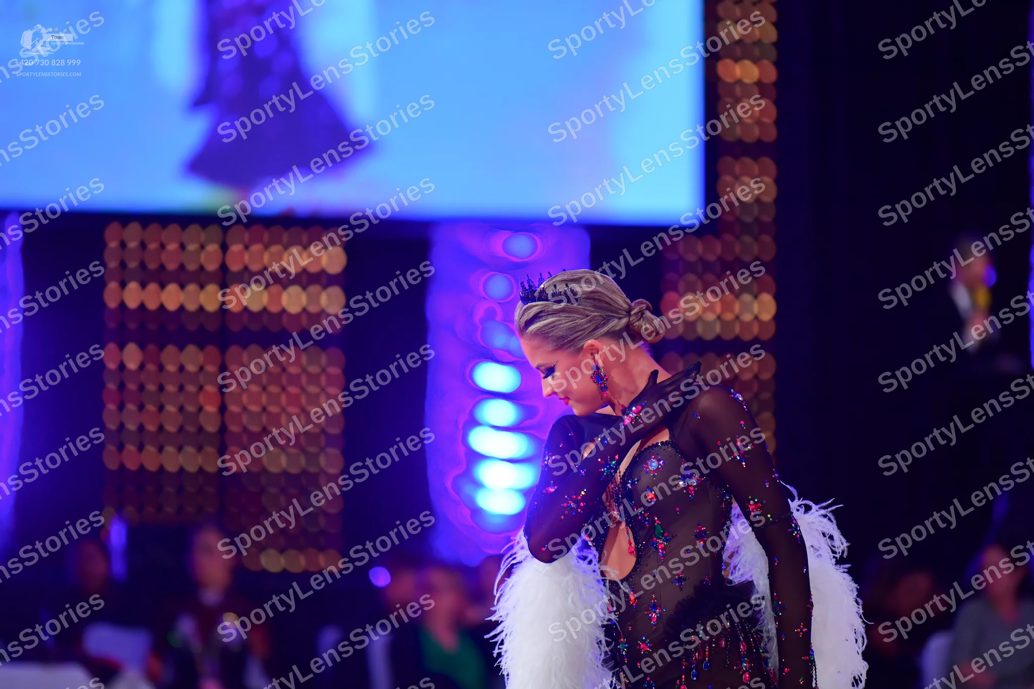 Dancesport competitor: Female dancer: dark latin dress with pink and silver sequins, sheer mesh fabric,
