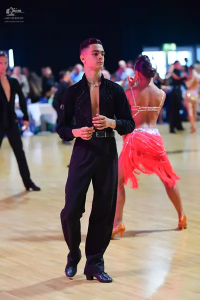 Dancesport competitor: Male dancer: black long-sleeved shirt and black trousers