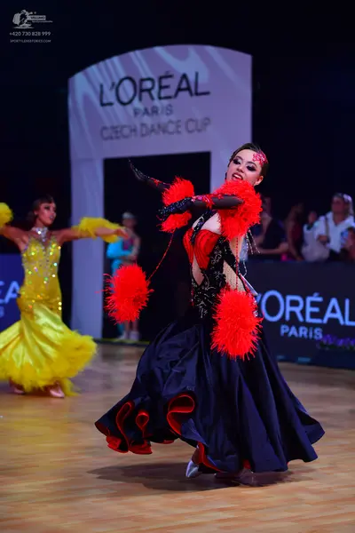 Dancesport competitor: Female dancer 1: yellow ballroom dress with sequins and a voluminous skirt
