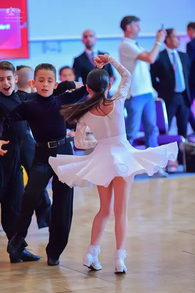 Dancesport competitor: Male dancer: black long-sleeved turtleneck and black trousers with a black belt