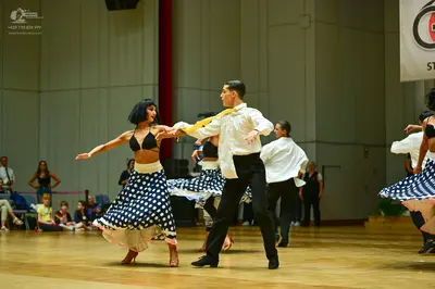 Dancesport competitor: Female dancer: black bra-style top and a black and white polka dot skirt with a 