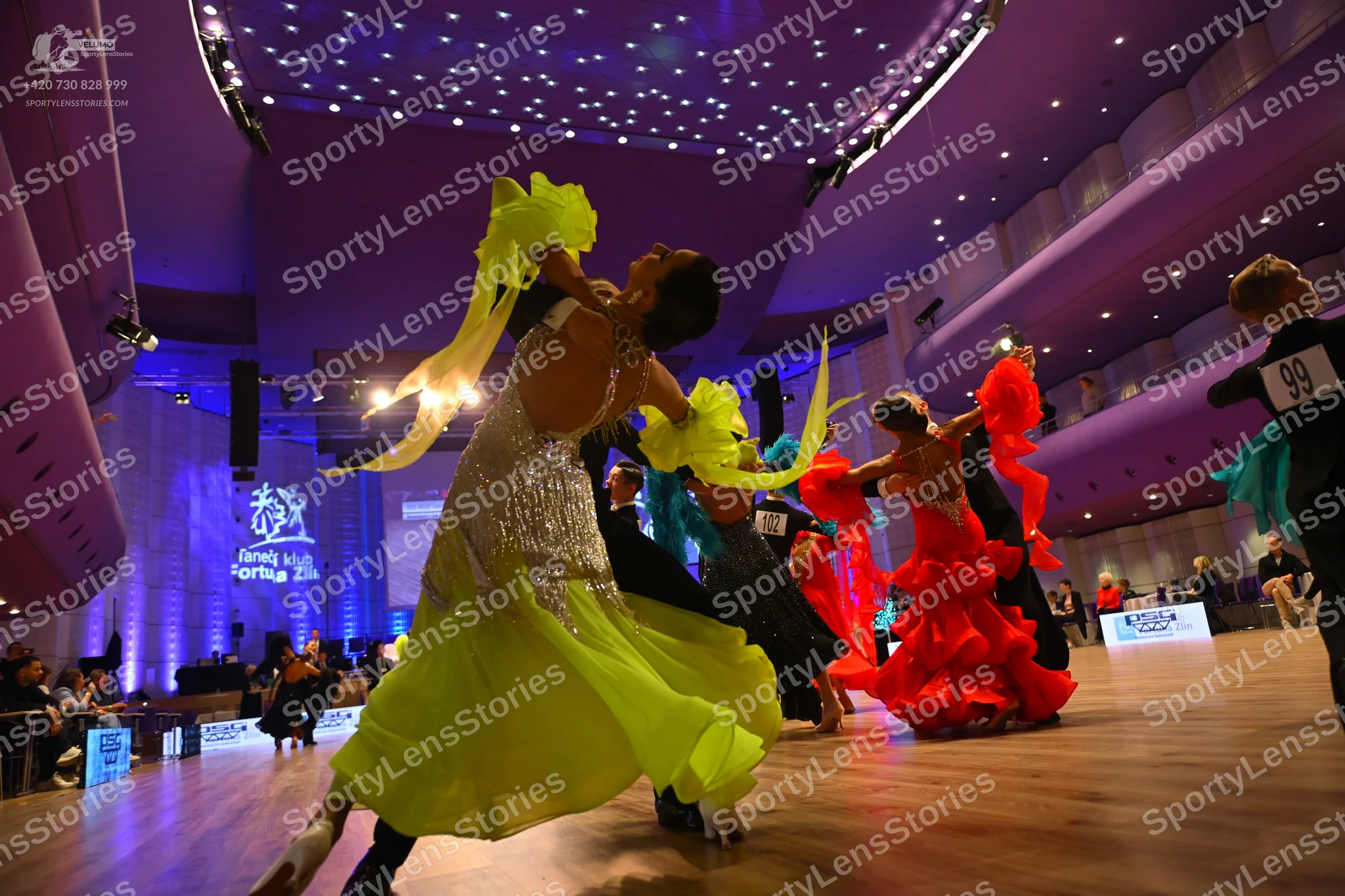 Dancesport competitor: Female dancer: lime yellow Latin dress with a sequined bodice and long, flowing