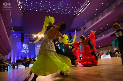 Dancesport competitor: Female dancer: lime yellow Latin dress with a sequined bodice and long, flowing 