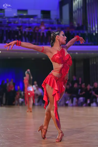 Dancesport competitor: Female dancers: red Latin dance dresses with fringe and red wristbands