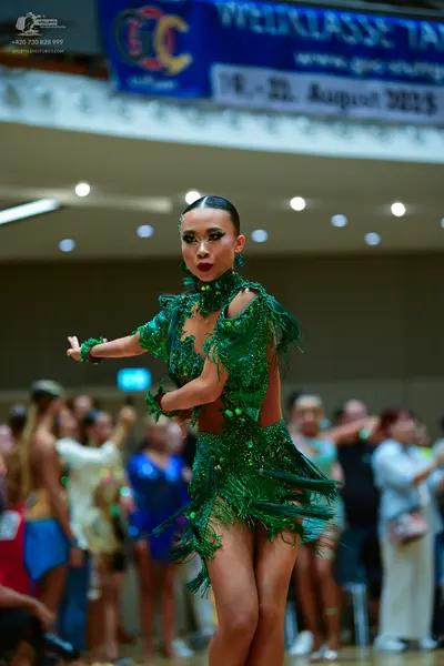 Dancesport competitor: Female dancer: emerald green latin dance dress with heavy sequin embellishments,