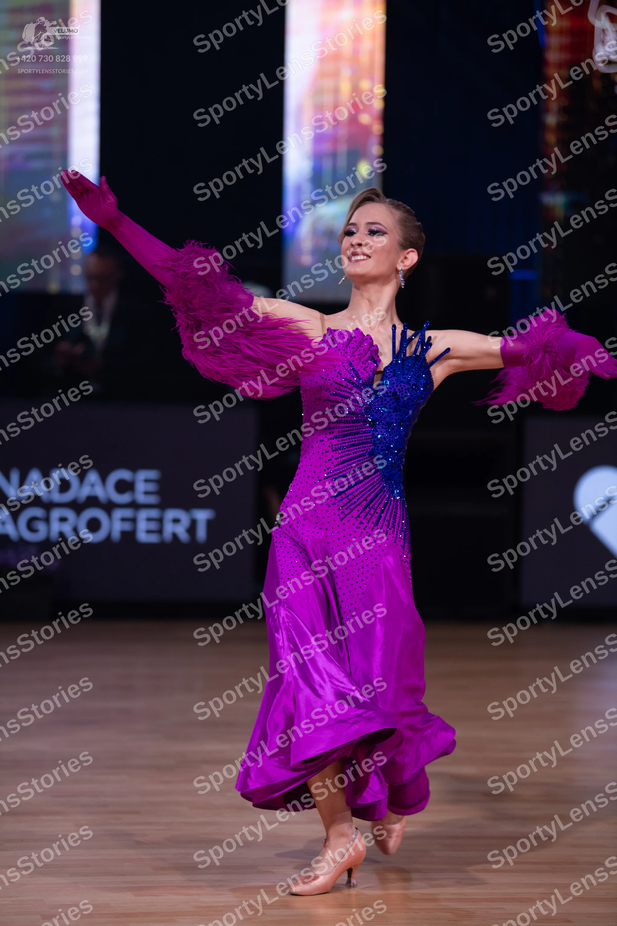 Dancesport competitor: Female dancer: magenta satin ballroom dress with a dark blue sequined bodice and