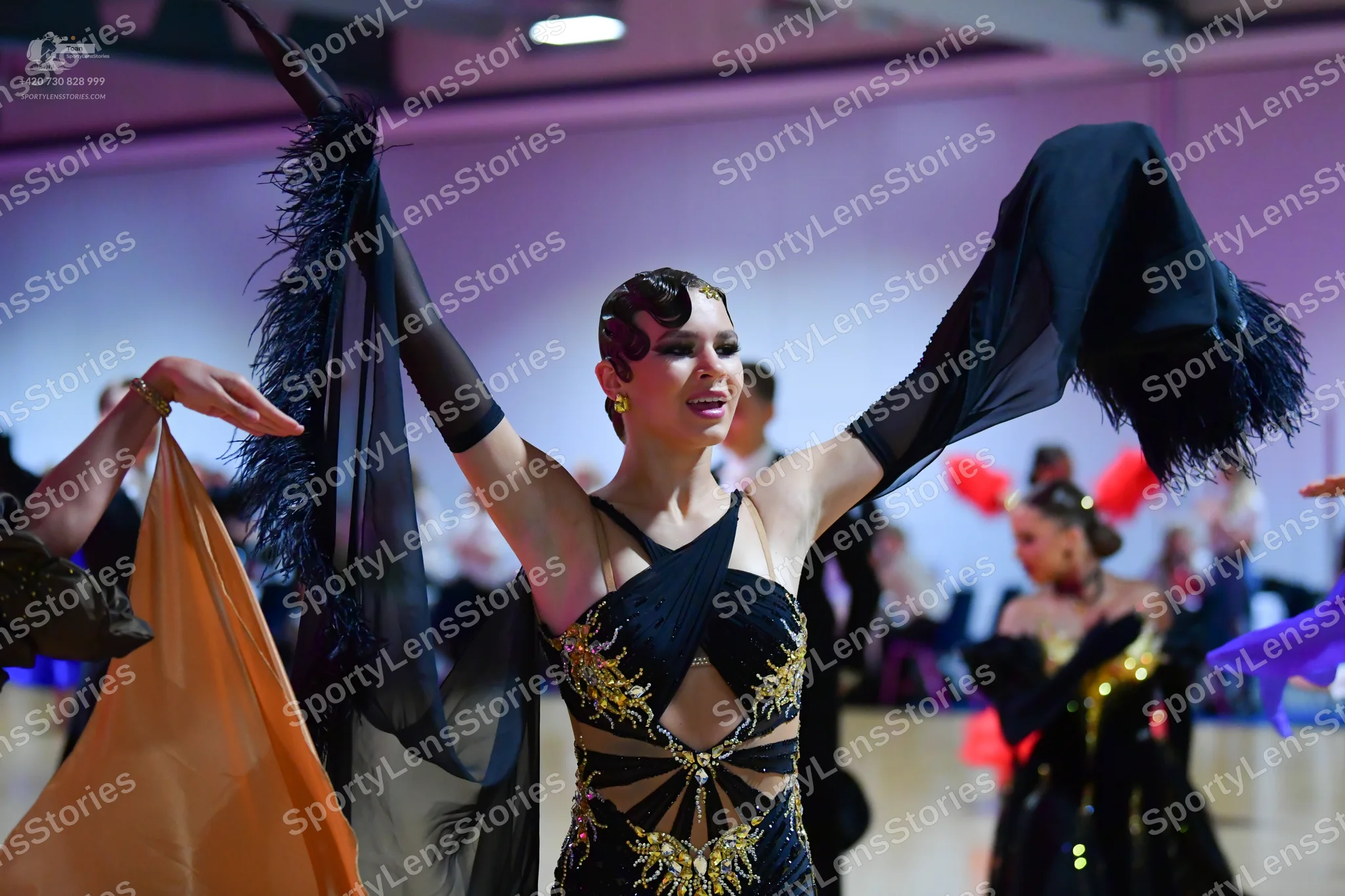 Dancesport competitor: Central dancer: black Latin dance dress with gold sequin/embellished patterns, n