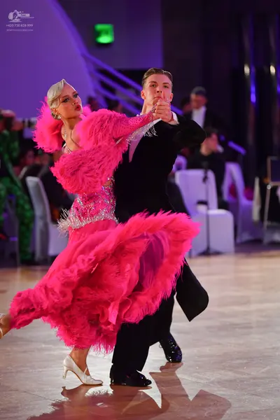 Dancesport competitor: Female dancer: bright pink Latin dance dress with a sequined bodice and volumino
