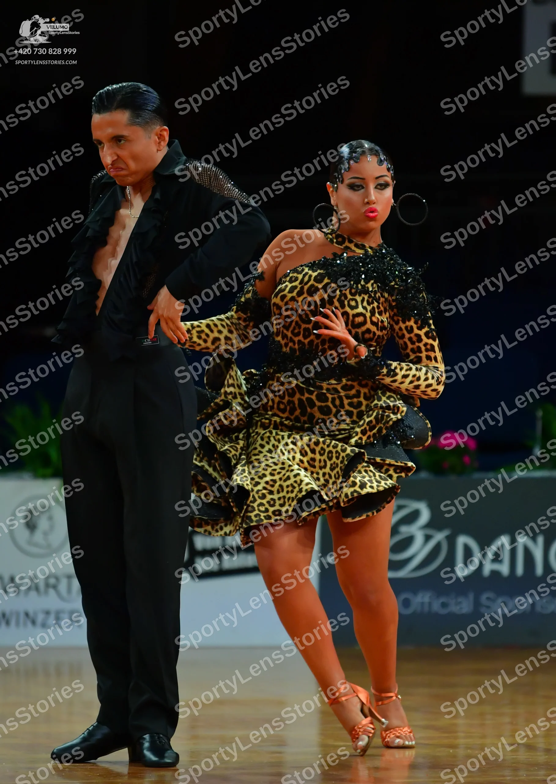 Dancesport competitor: Male dancer: black Latin-style dance shirt with ruffled edges and black trousers