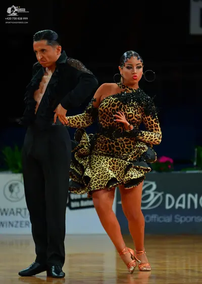 Dancesport competitor: Male dancer: black Latin-style dance shirt with ruffled edges and black trousers