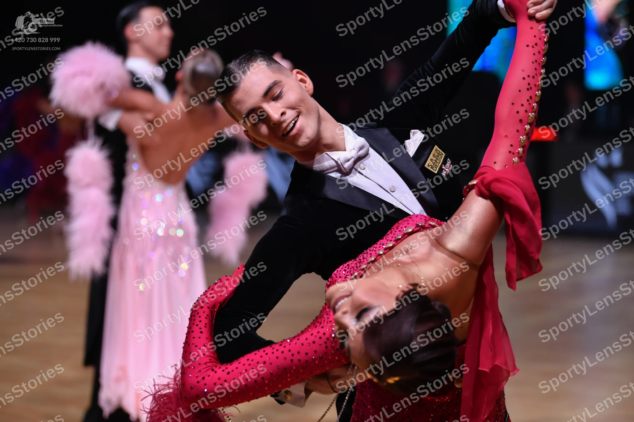 Dancesport competitor: Male dancer (foreground): black suit with a white shirt and bowtie
