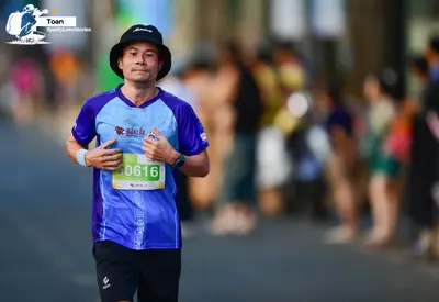 Marathon runner #0616: Runner 1: blue and light blue jersey, black shorts, black bucket hat, white wris