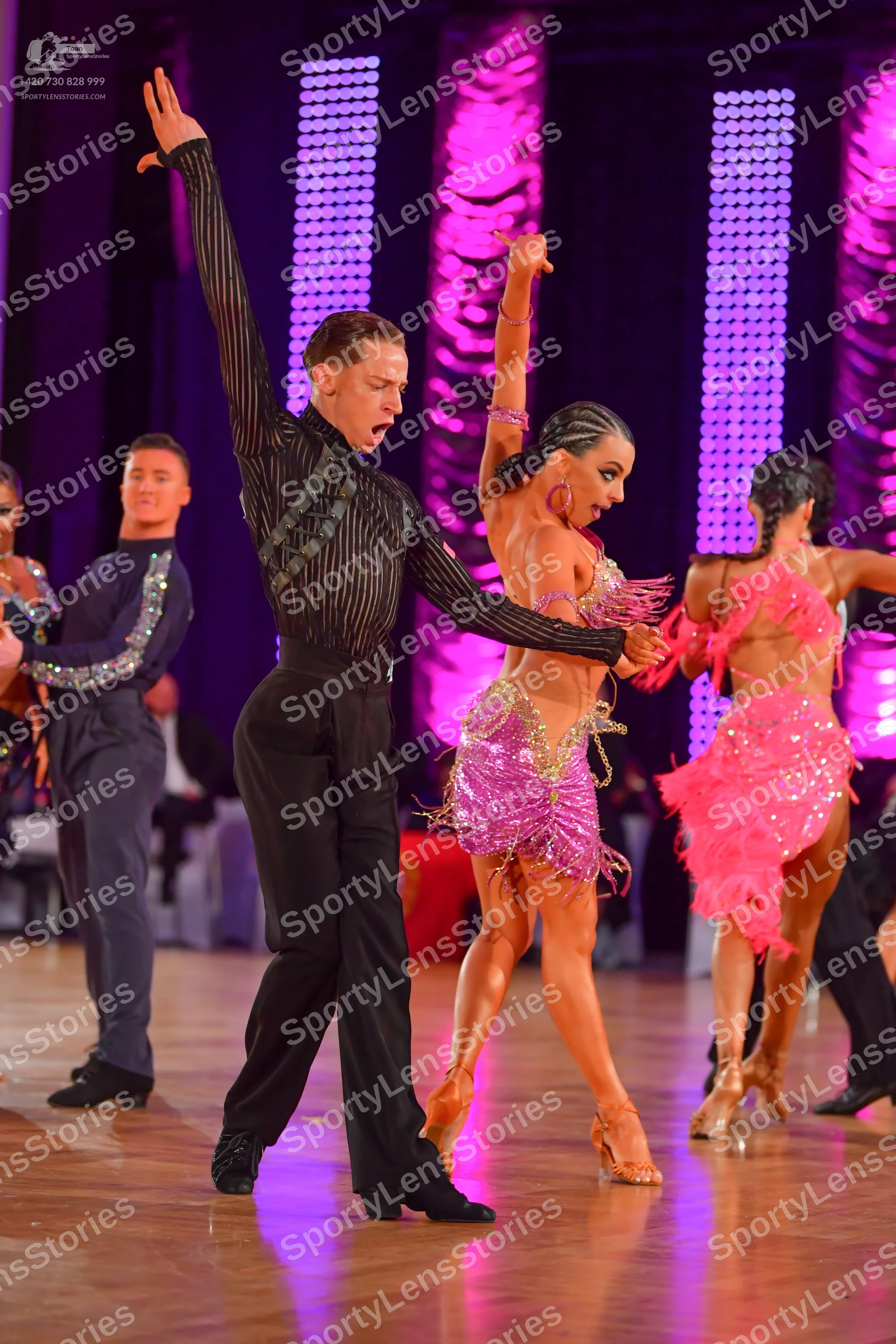 Dancesport competitor: Male dancer in front: black long-sleeve shirt with vertical sequin stripes and b