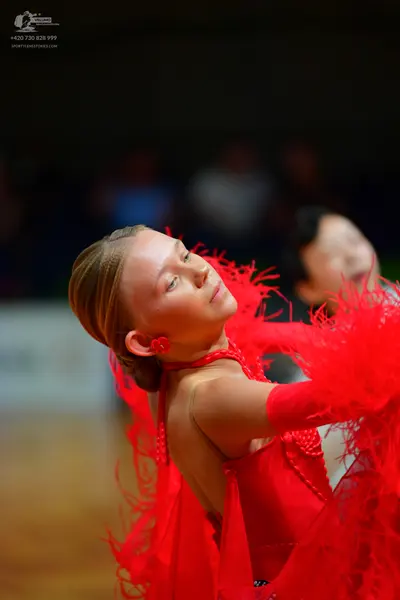 Dancesport competitor: Female dancer: red Latin dress with feather-like fringe