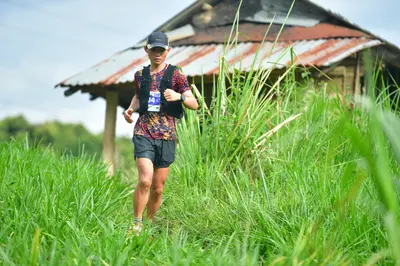Marathon runner #M201: Runner 1: patterned dark jersey, black shorts, black cap, black hydration vest, 