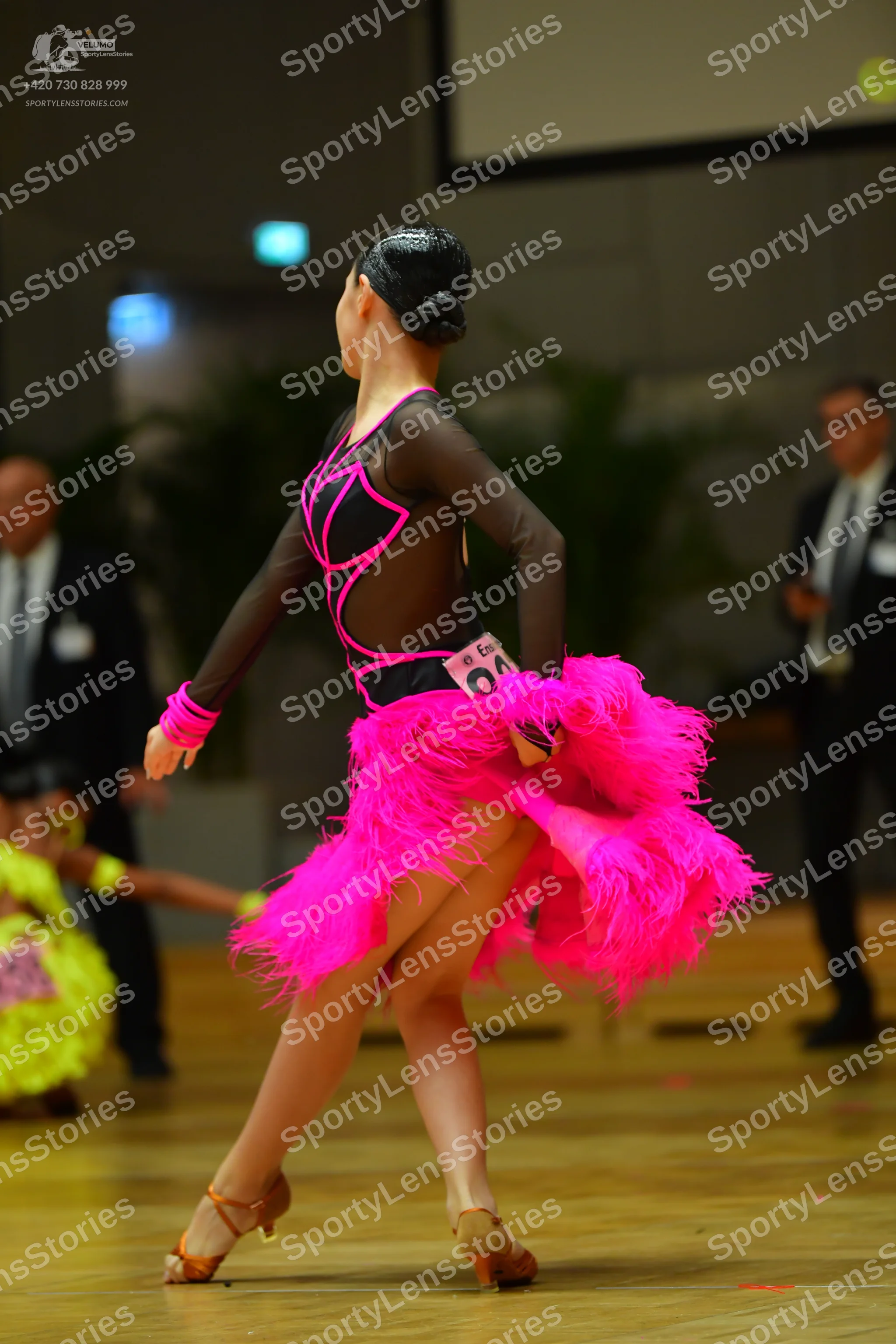 Dancesport competitor #146: Female dancer: black long-sleeved latin dress with pink trim and a large, volumi
