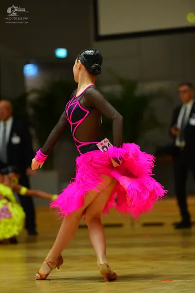 Dancesport competitor #146: Female dancer: black long-sleeved latin dress with pink trim and a large, volumi