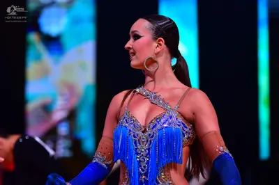 Dancesport competitor: Female dancer: bright blue latin dress with fringe, heavily embellished with sil