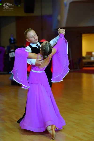 Dancesport competitor: Male dancer: white long-sleeved shirt, black vest, black trousers, and black tie