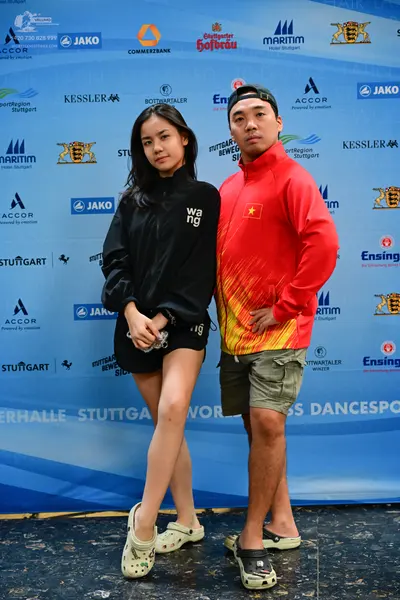 Dancesport competitor: Male dancer: red and yellow gradient long-sleeved jacket, khaki shorts, and blac