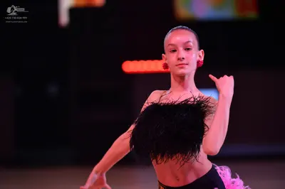 Dancesport competitor: Female dancer: black Latin costume with feathery black texture on the bodice and