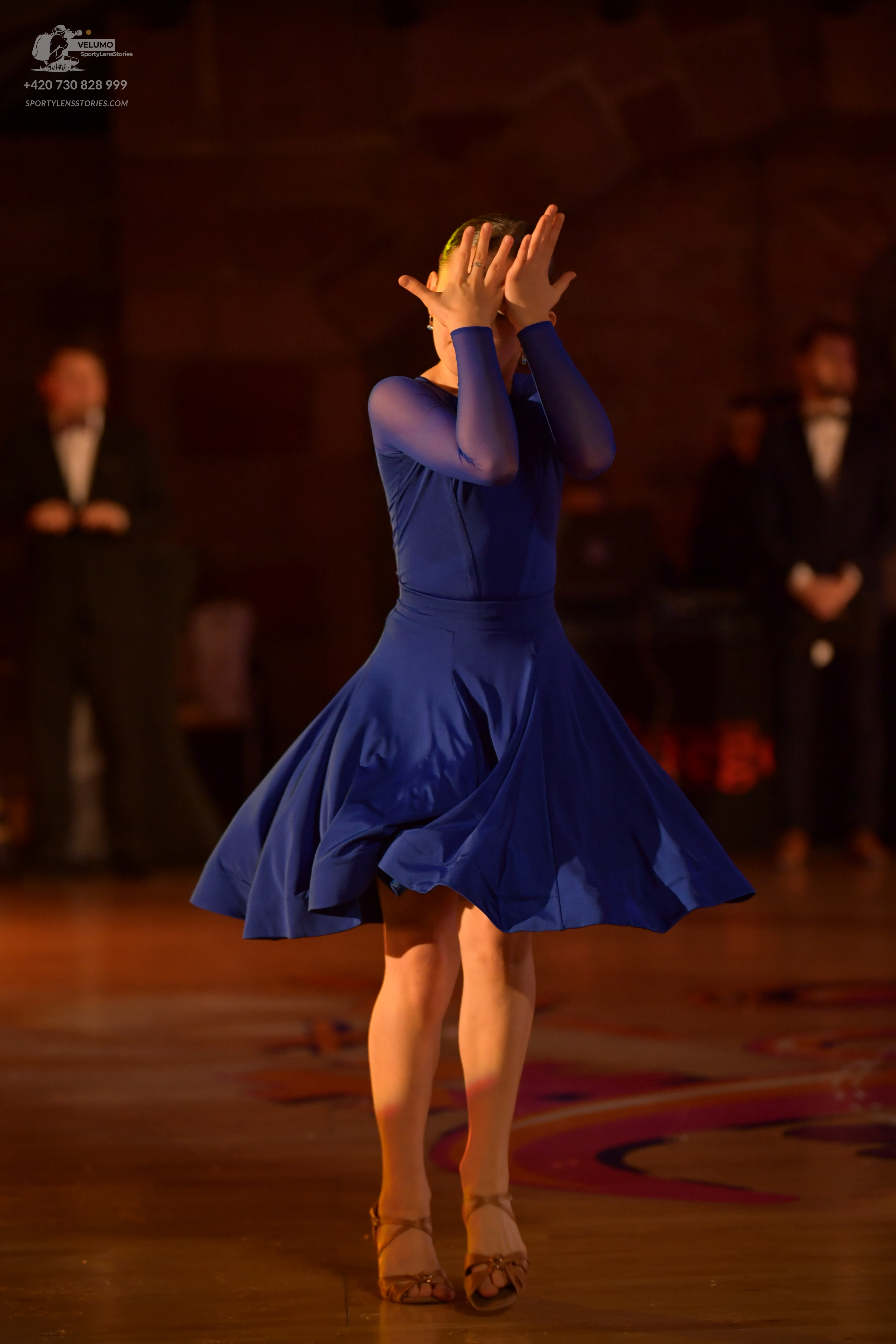 Dancesport competitor: Female dancer: blue latin dress with long sleeves and a flared skirt