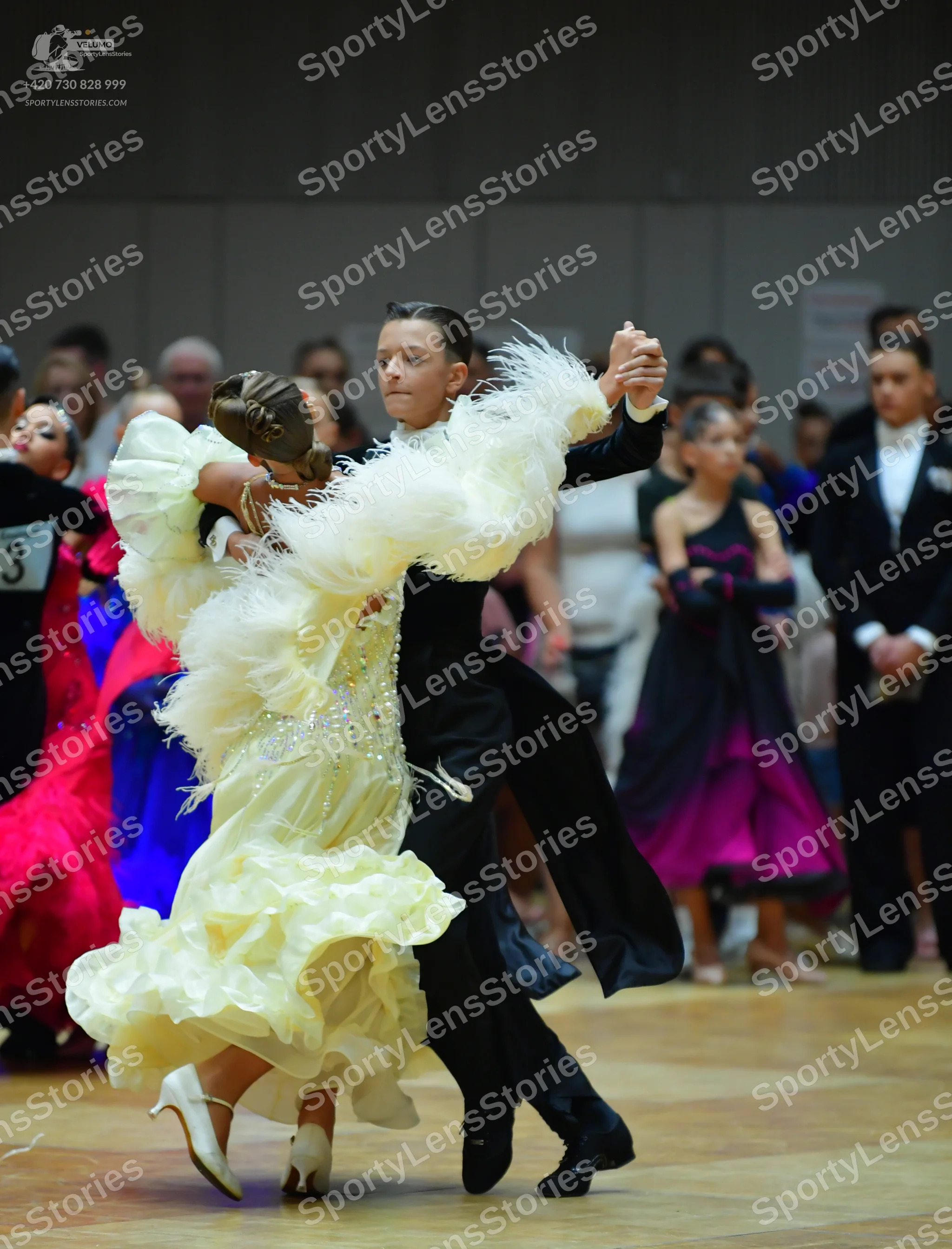 Dancesport competitor: Main female dancer: cream-colored, voluminous ballroom dress with large ruffled,