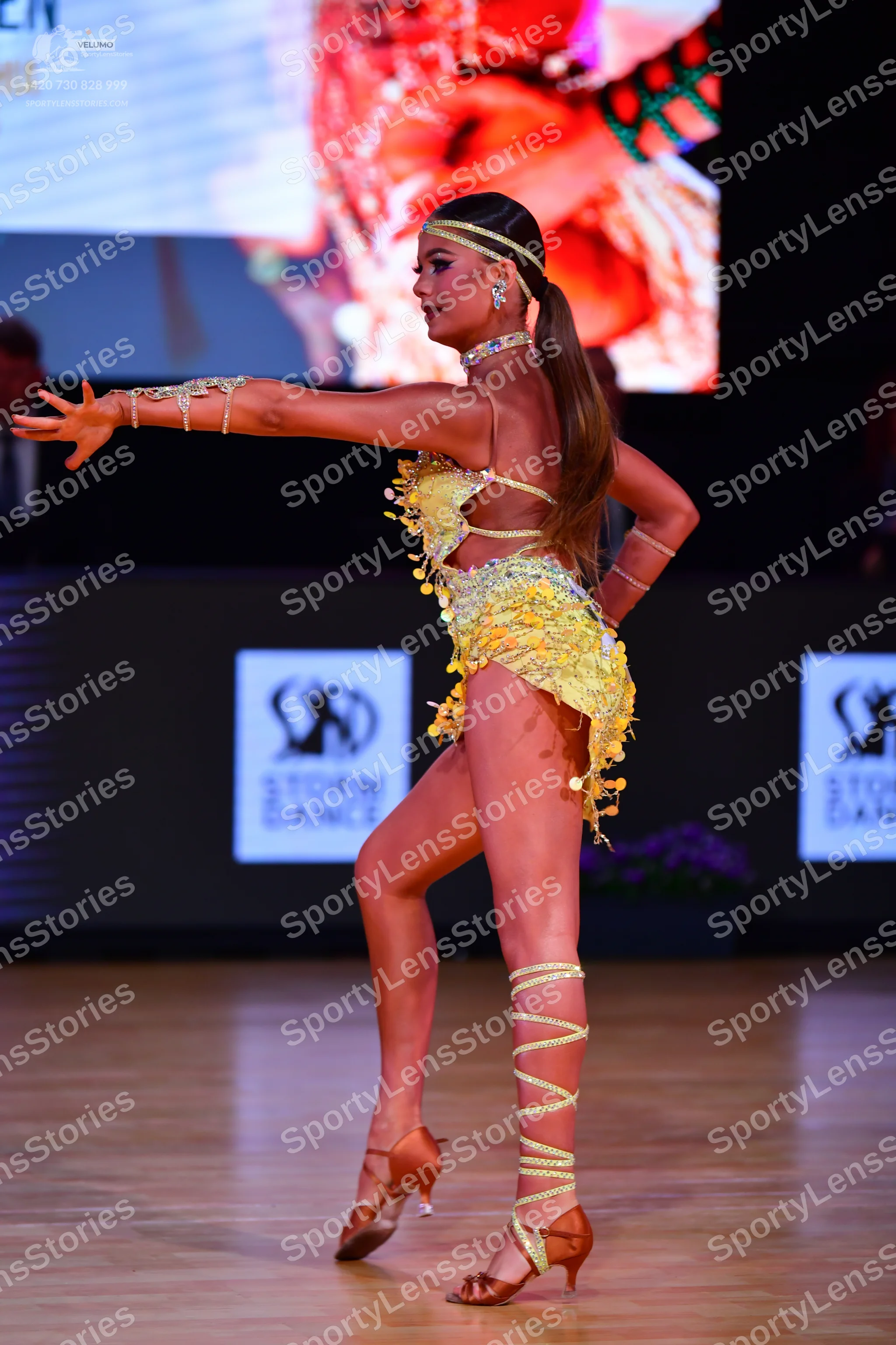 Dancesport competitor: Female dancer: yellow Latin dance costume decorated with sequins and crystals, f