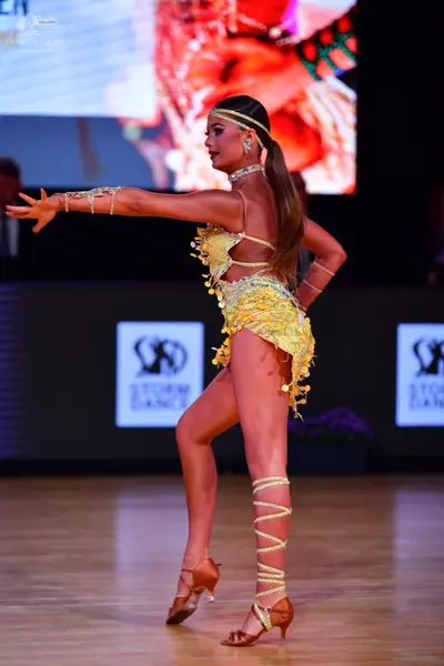 Dancesport competitor: Female dancer: yellow Latin dance costume decorated with sequins and crystals, f