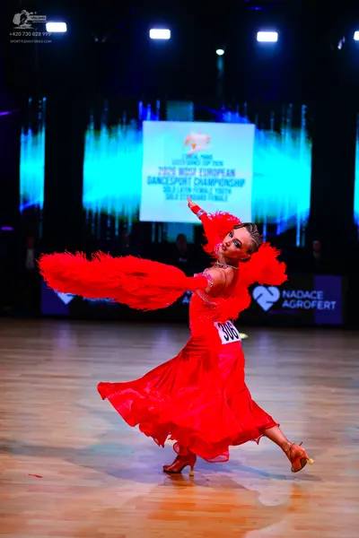Dancesport competitor: Female dancer: red latin dress with large red feather-like trim on the sleeves