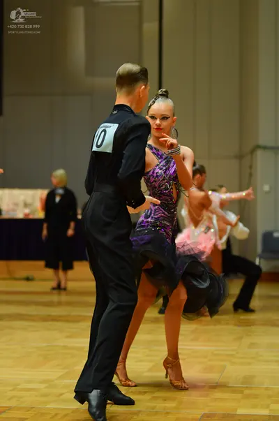 Dancesport competitor: Male dancer (foreground): black dance shirt and trousers