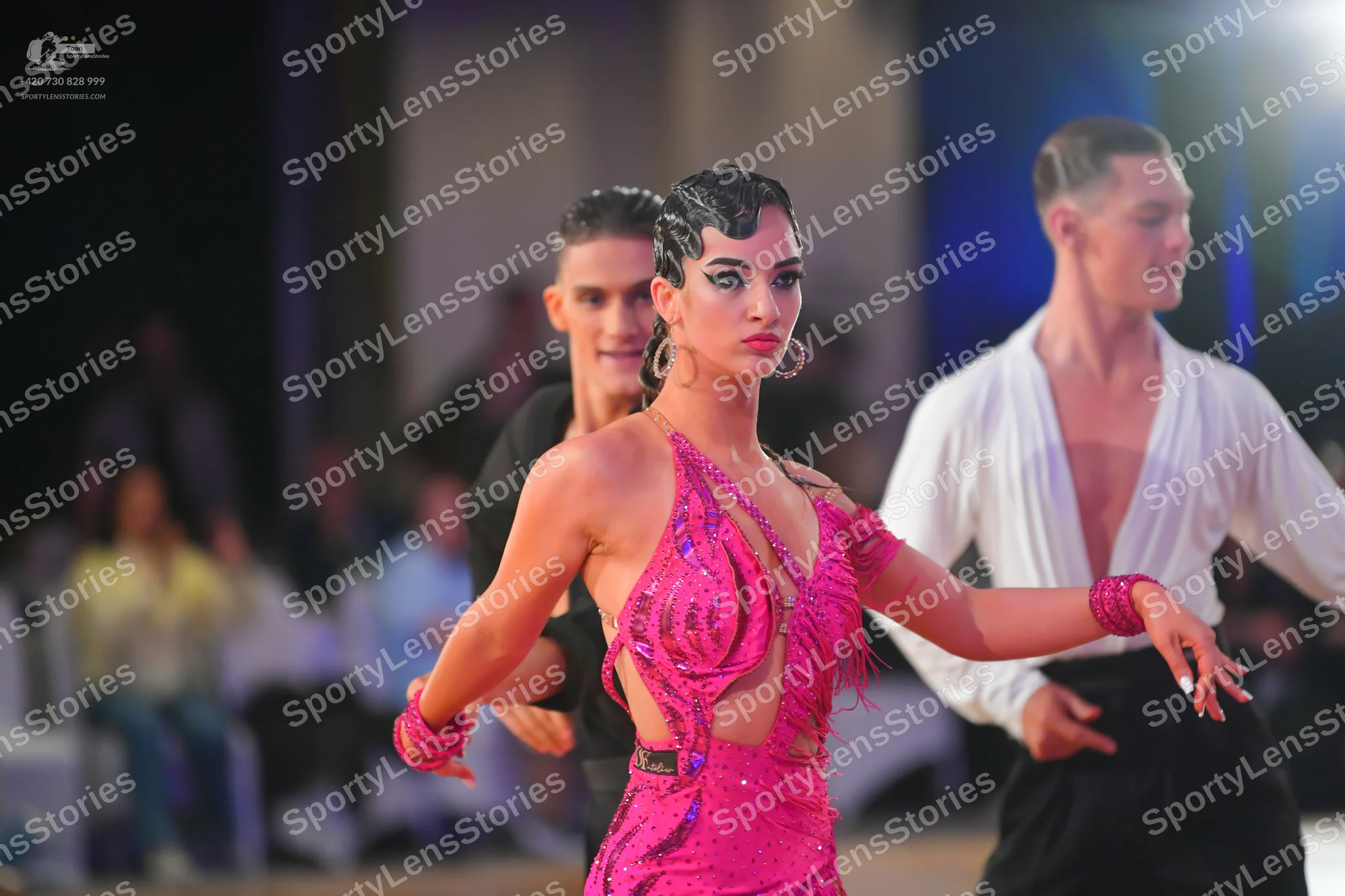 Dancesport competitor: Female dancer: pink Latin dress with sequins and fringe, featuring cutouts, pair