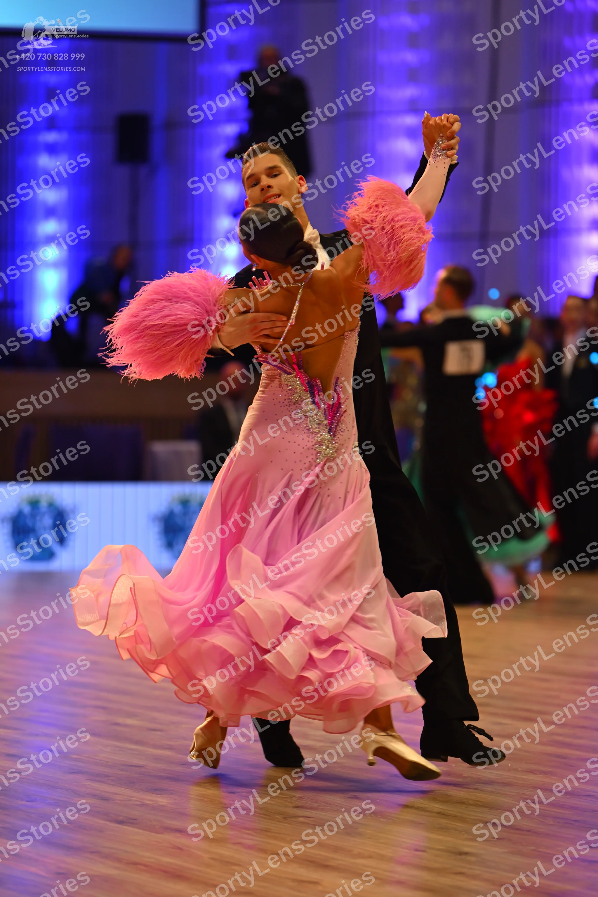 Dancesport competitor: Female dancer: pink ballgown with a voluminous, multi-layered ruffled skirt, a s