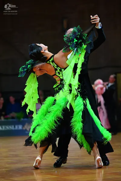 Dancesport competitor: Female dancer: lime green and black Latin dance dress with extensive lime green 