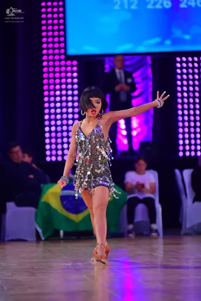 Dancesport competitor: Female dancer: silver sequined latin dress with large hoop earrings and bracelet
