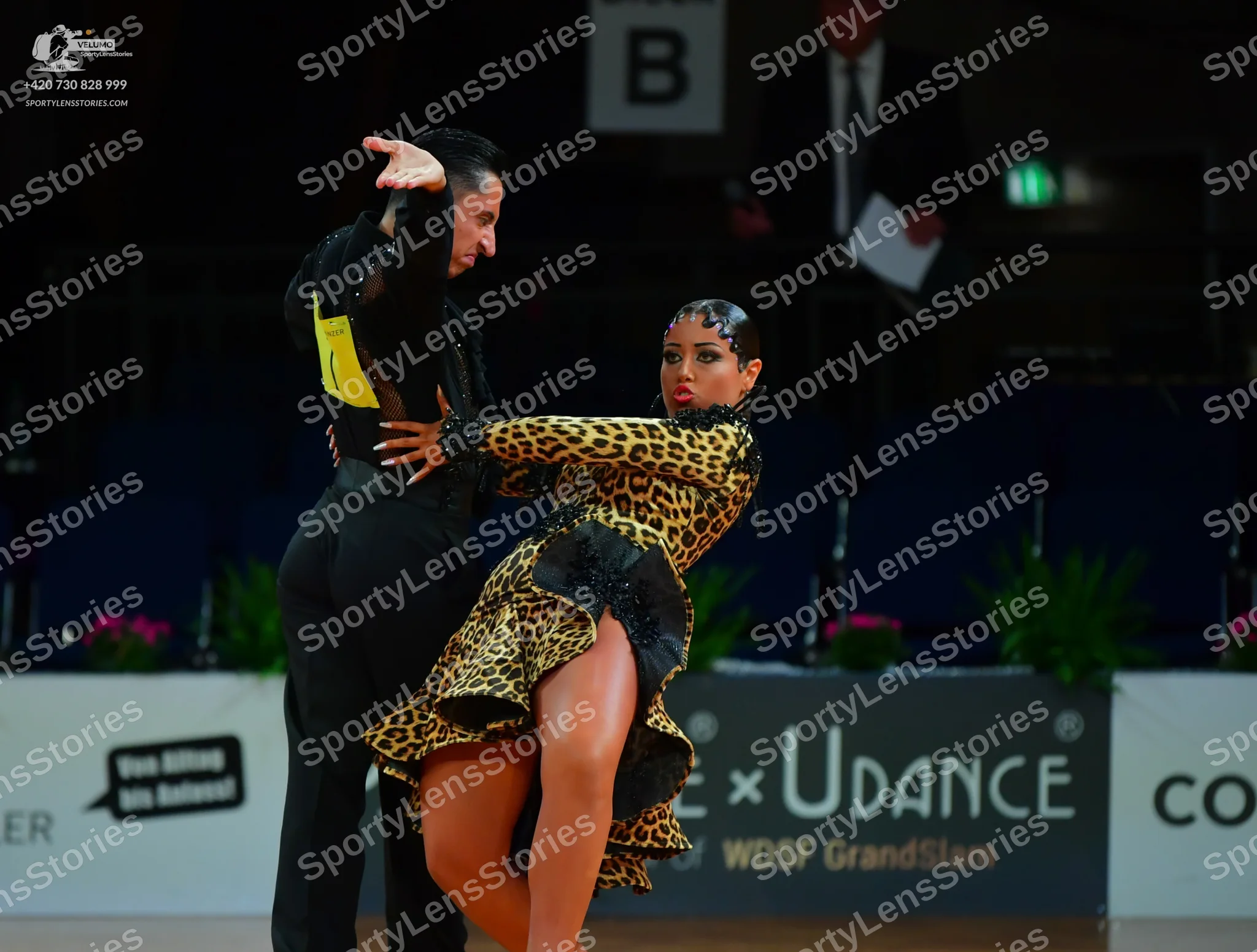 Dancesport competitor: Male dancer: black long-sleeved shirt with a yellow patch on the side and black