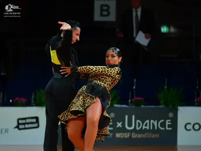 Dancesport competitor: Male dancer: black long-sleeved shirt with a yellow patch on the side and black 