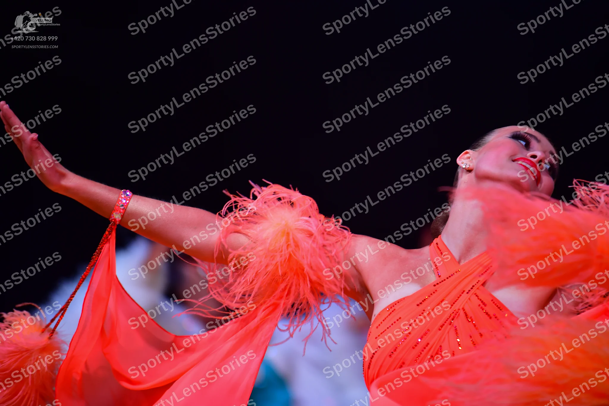 Dancesport competitor: Female dancer: bright orange Latin dance dress featuring rhinestone embellishmen