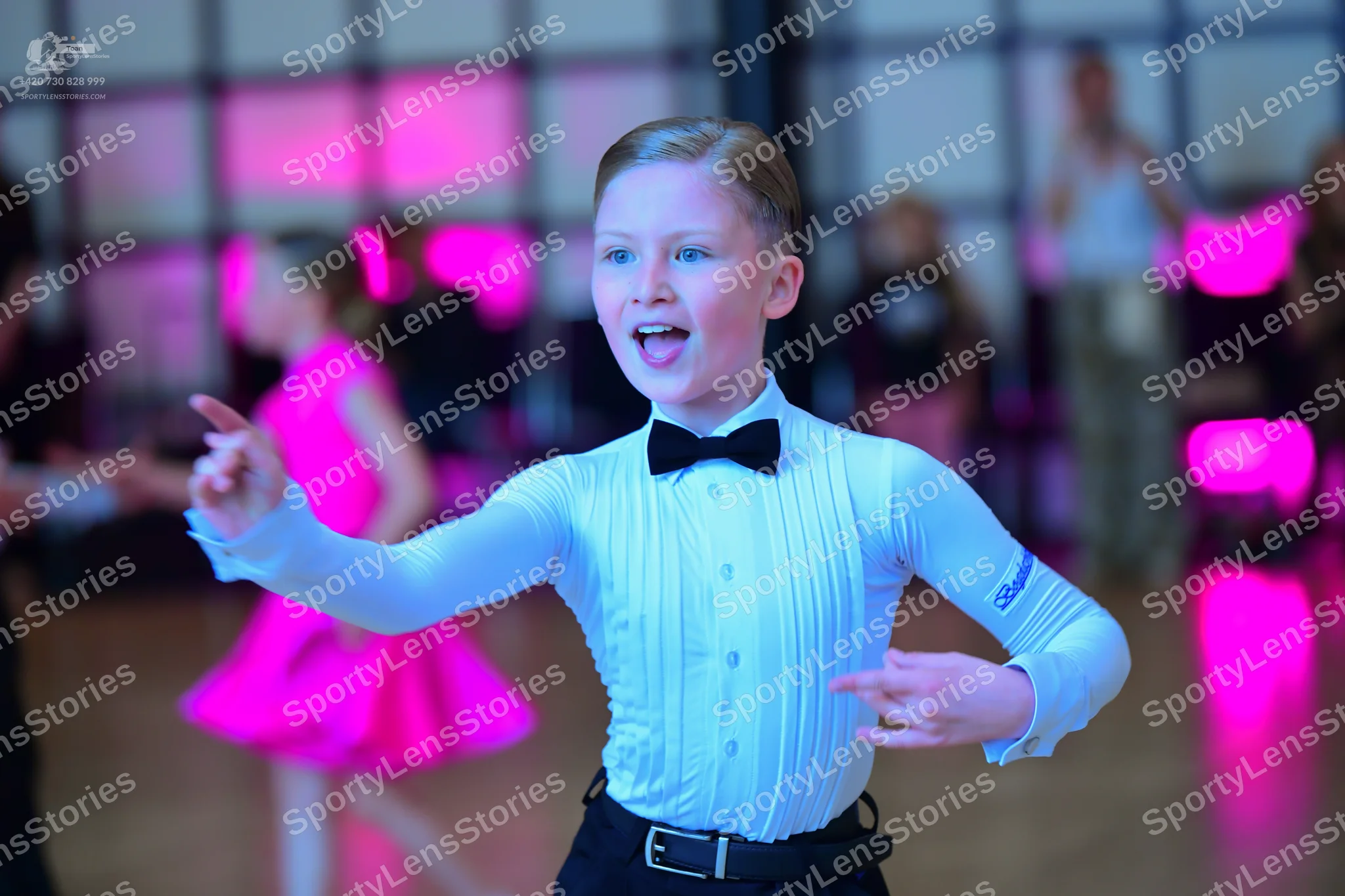 Dancesport competitor: Male dancer: light blue long-sleeved shirt with vertical pleats, black bow tie, 