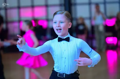 Dancesport competitor: Male dancer: light blue long-sleeved shirt with vertical pleats, black bow tie, 
