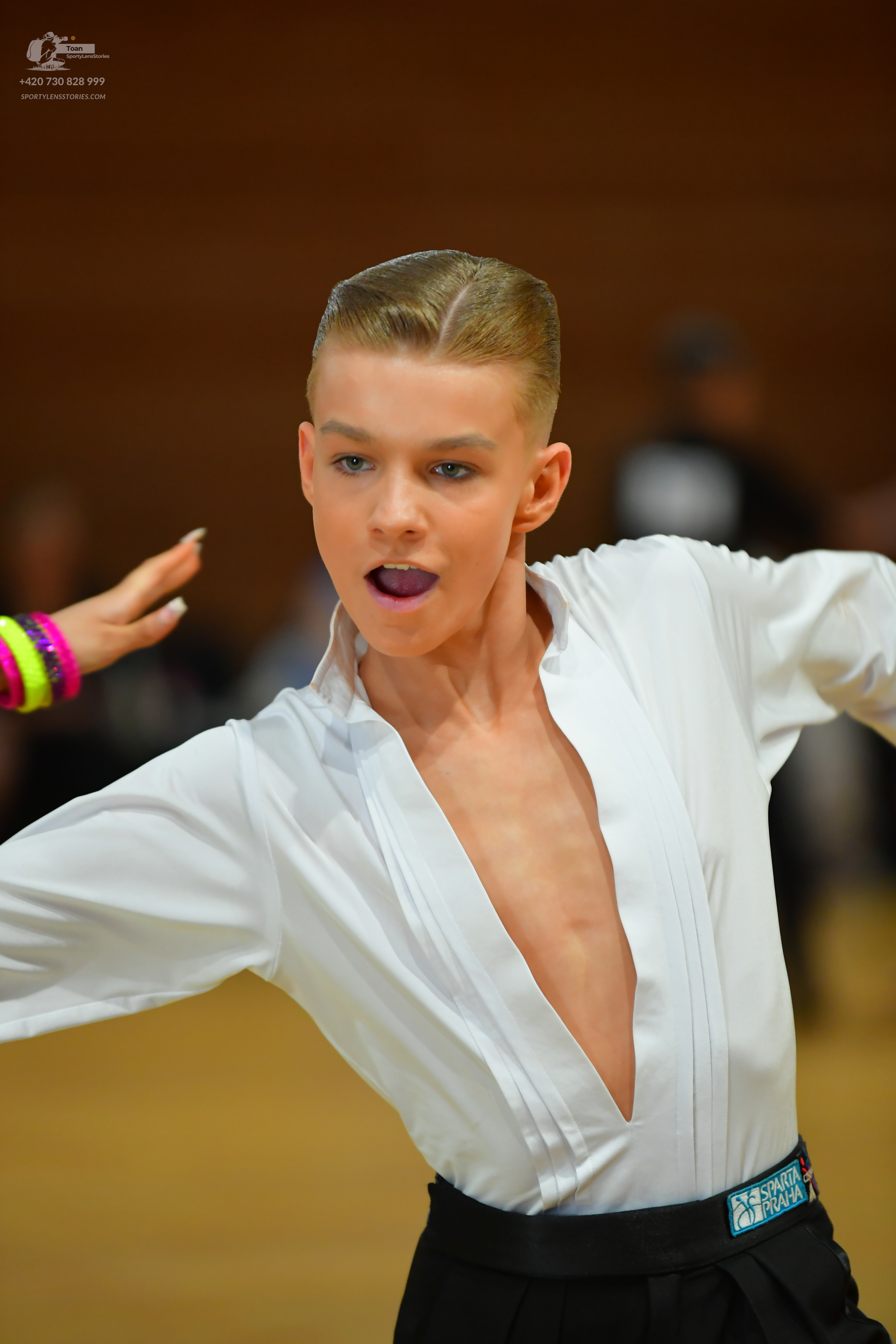 Dancesport competitor: ** White (off-white) fitted bodysuit with a plunging V-neck