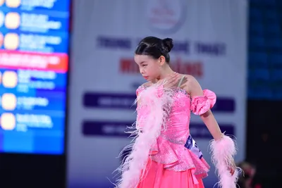Dancesport competitor: Here’s a description of the dancers’ costumes based on the photo:

**Dancer 1 (F