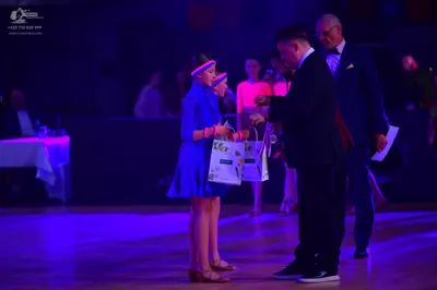Dancesport competitor: Female dancer: blue short dress with a pink headband