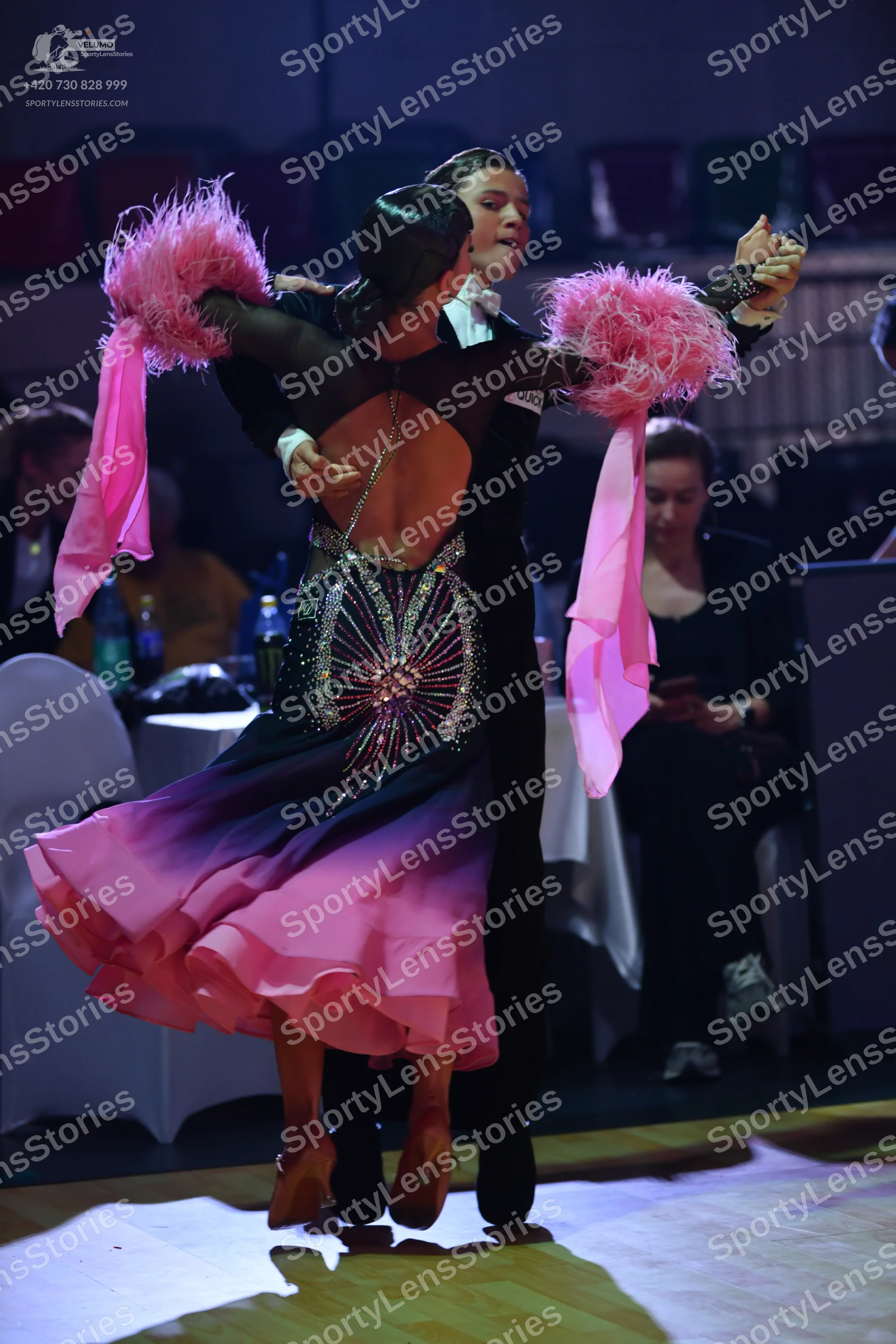 Dancesport competitor: Female dancer: black and pink ombre ballgown with a sequined sunburst pattern on