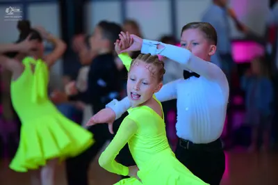 Dancesport competitor: Female dancer: neon lime green long-sleeved Latin dress