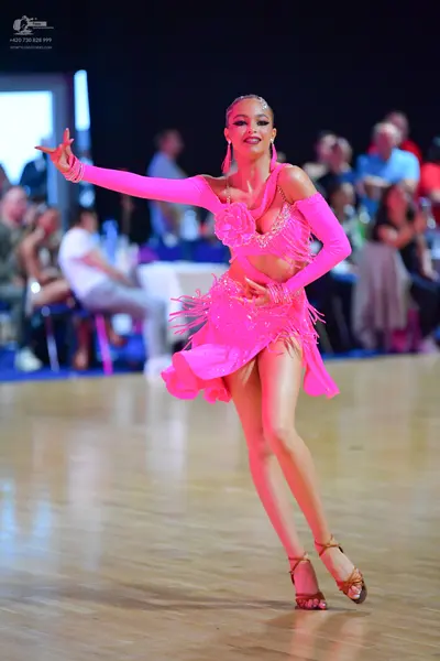 Dancesport competitor: Female dancer: bright pink latin dress with sequins and fringe
