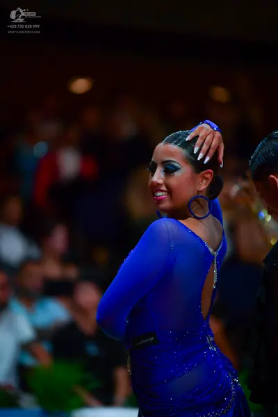 Dancesport competitor: Female dancer: royal blue latin dance dress with long sleeves, sheer fabric ador