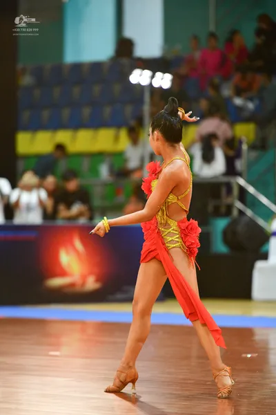 Dancesport competitor: ** Red Latin Dress
*   **Color:** Vibrant red
*   **Fabric:** Satin (appears to 